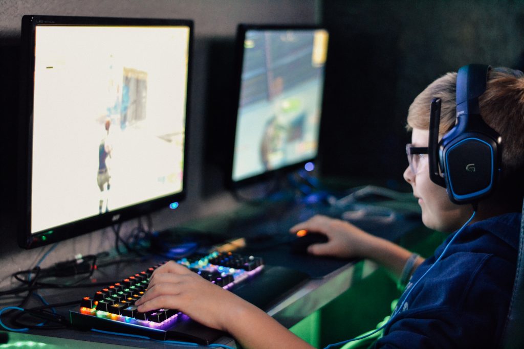 boy gaming behind keyboard and mouse