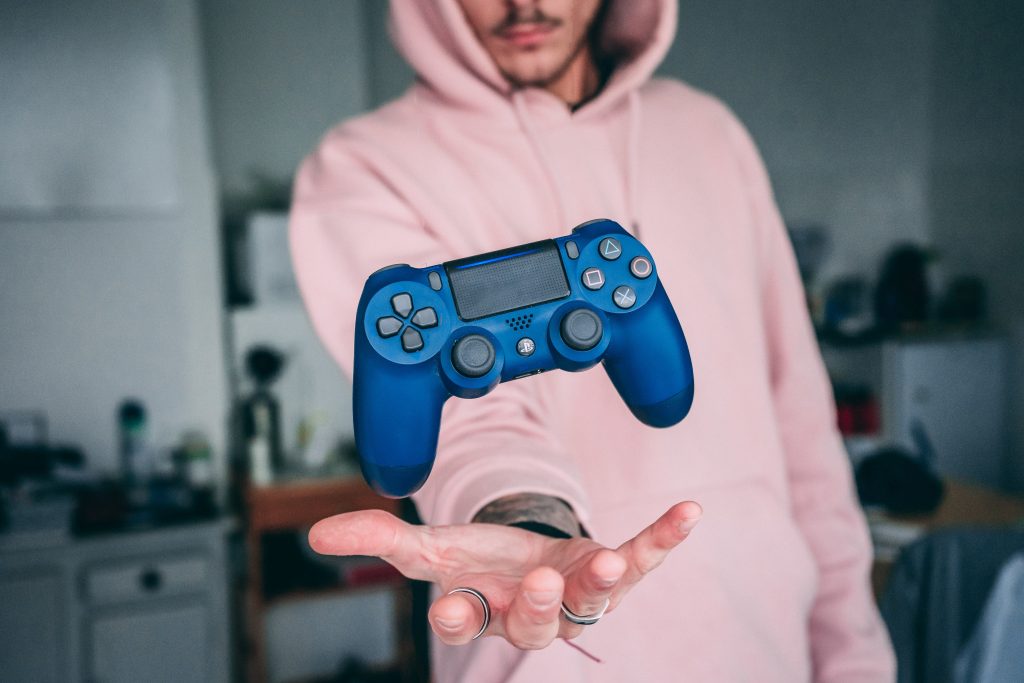 man holding a blue playstation controler